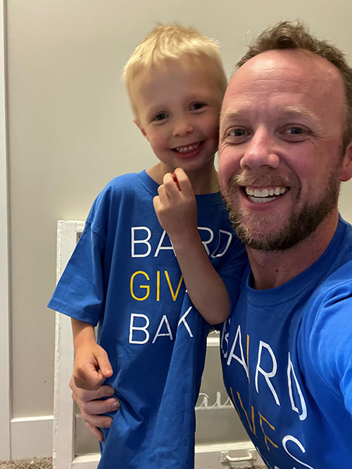 Man and son wearing Baird Cares t-shirts
