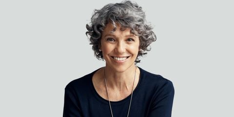 Photo of a woman wearing a black top with short grey hair.