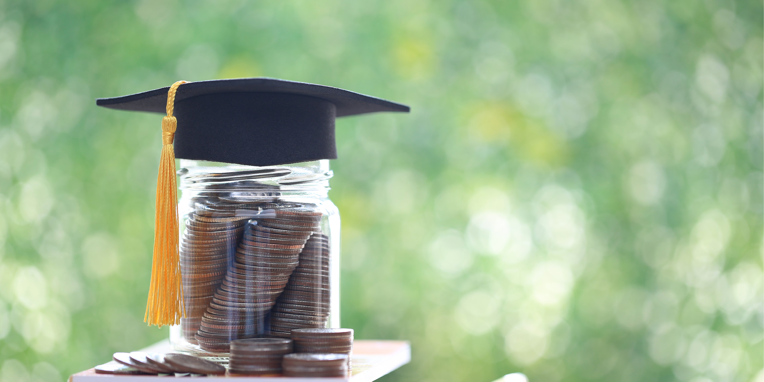 Jar of coins with a graduation cap as a cover.