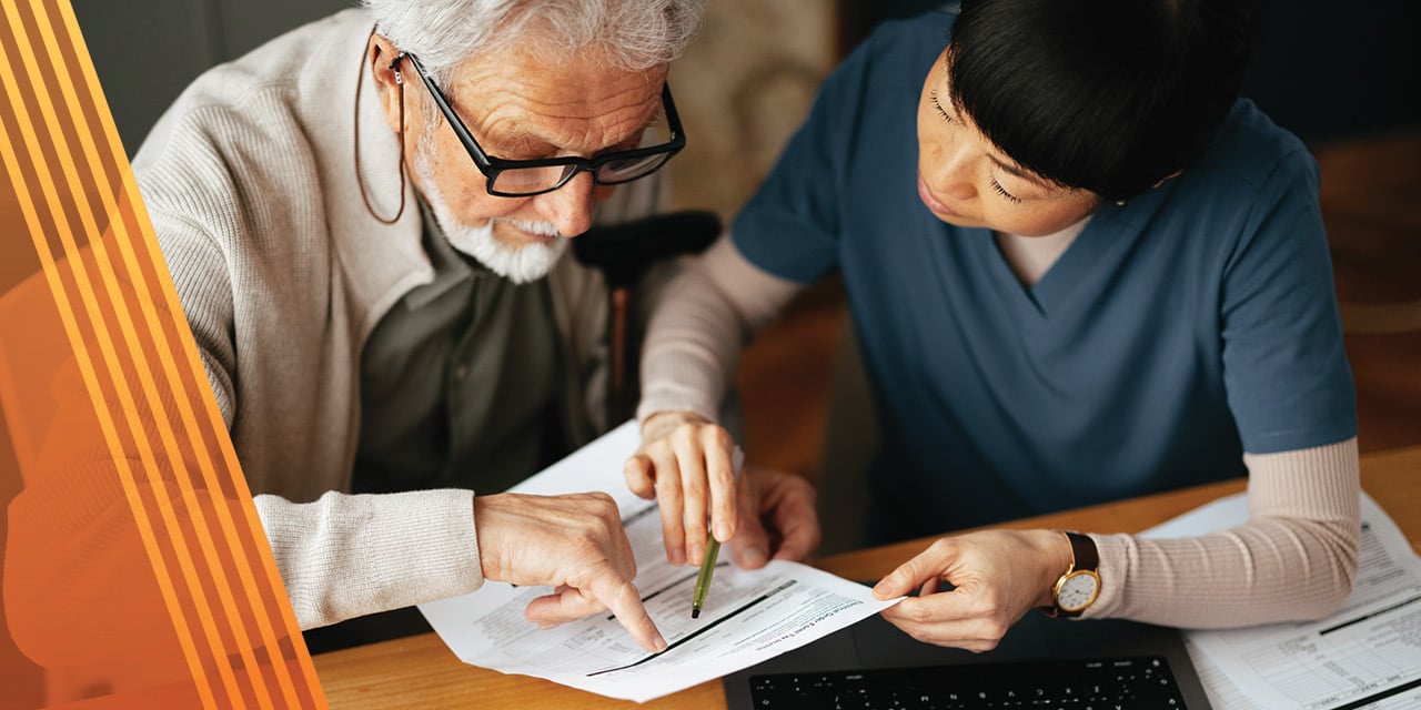 Two people sitting at a table reviewing paperwork.