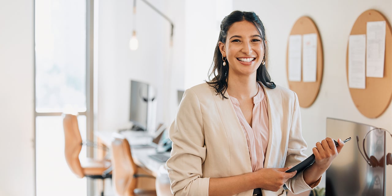 Young businesswoman standing in an office while holding a file folder.