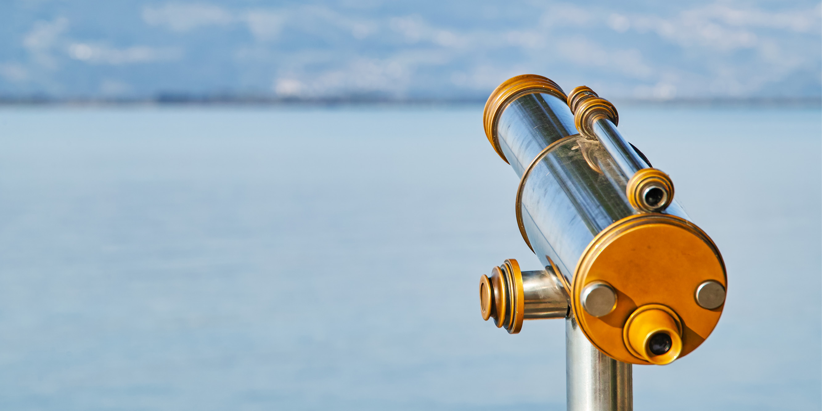 Telescope pointed toward a body of water.