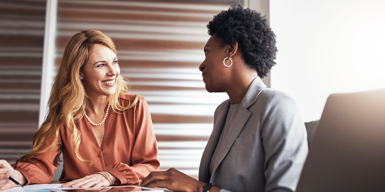 Two business women talking at a conference table