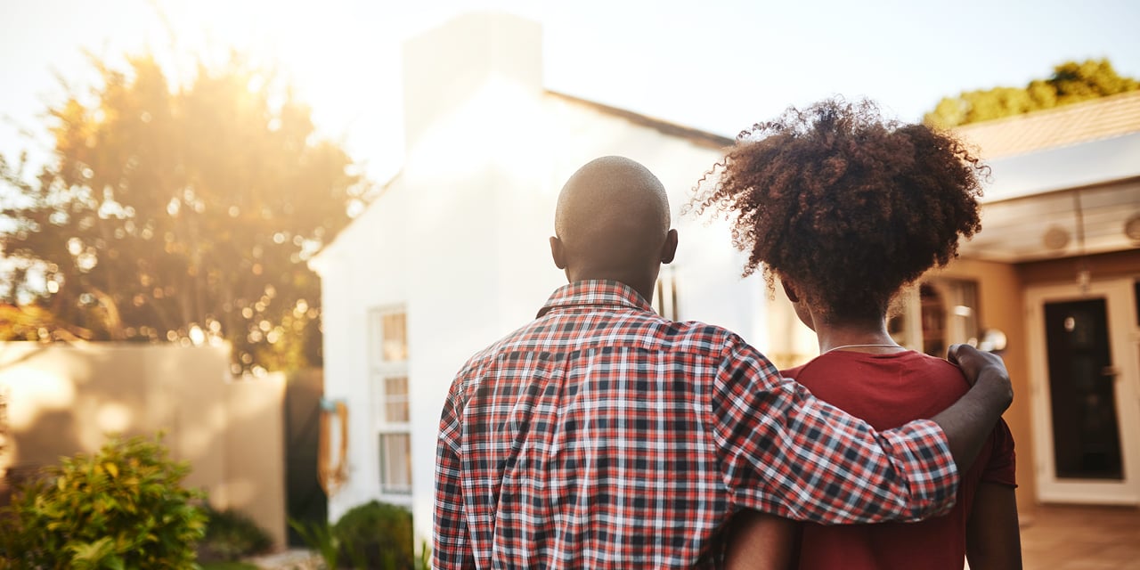 Man and woman looking at a house.