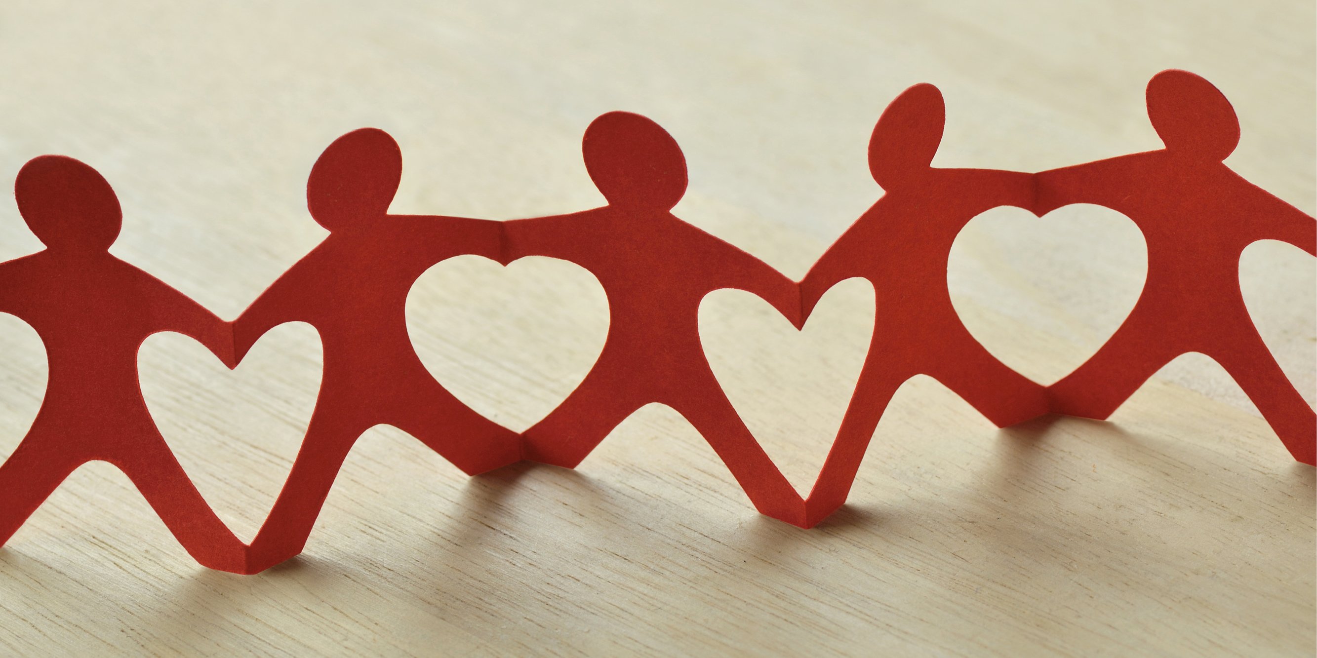 Red paper chain shaped like people with hearts between each figure.