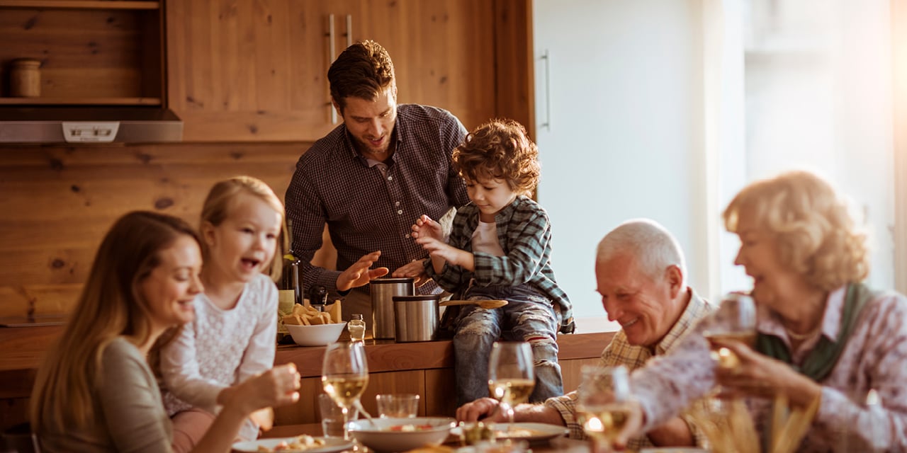 Multigenerational family together at a dining room table.