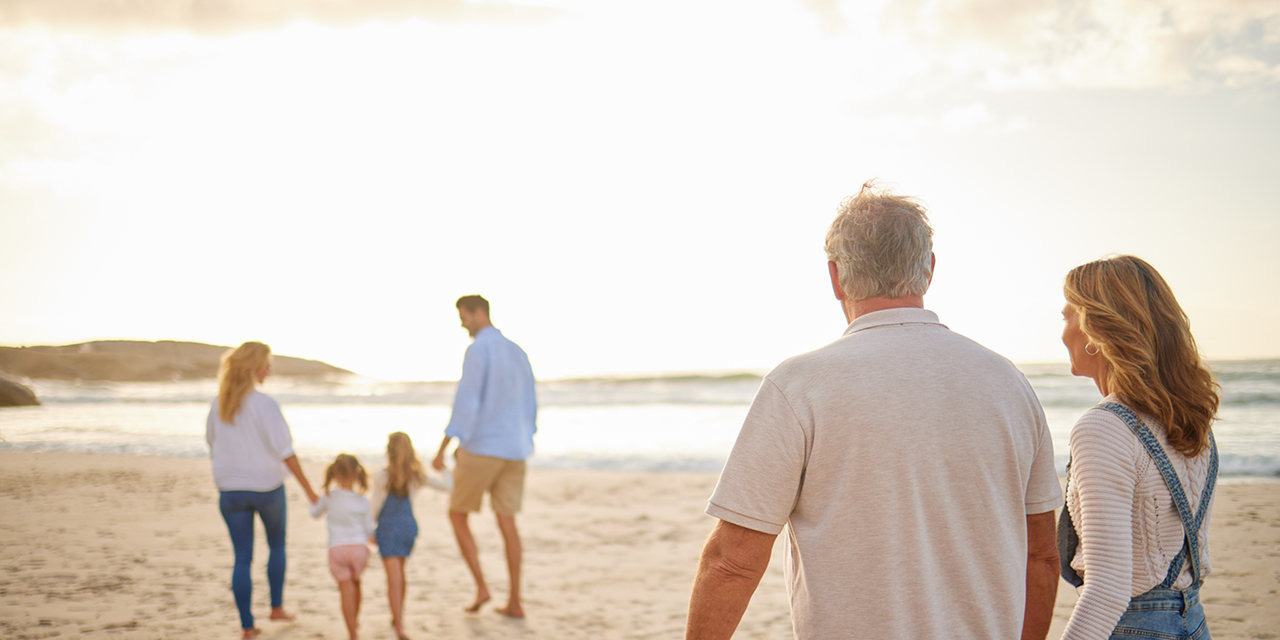 Multigeneration family walking on the beach