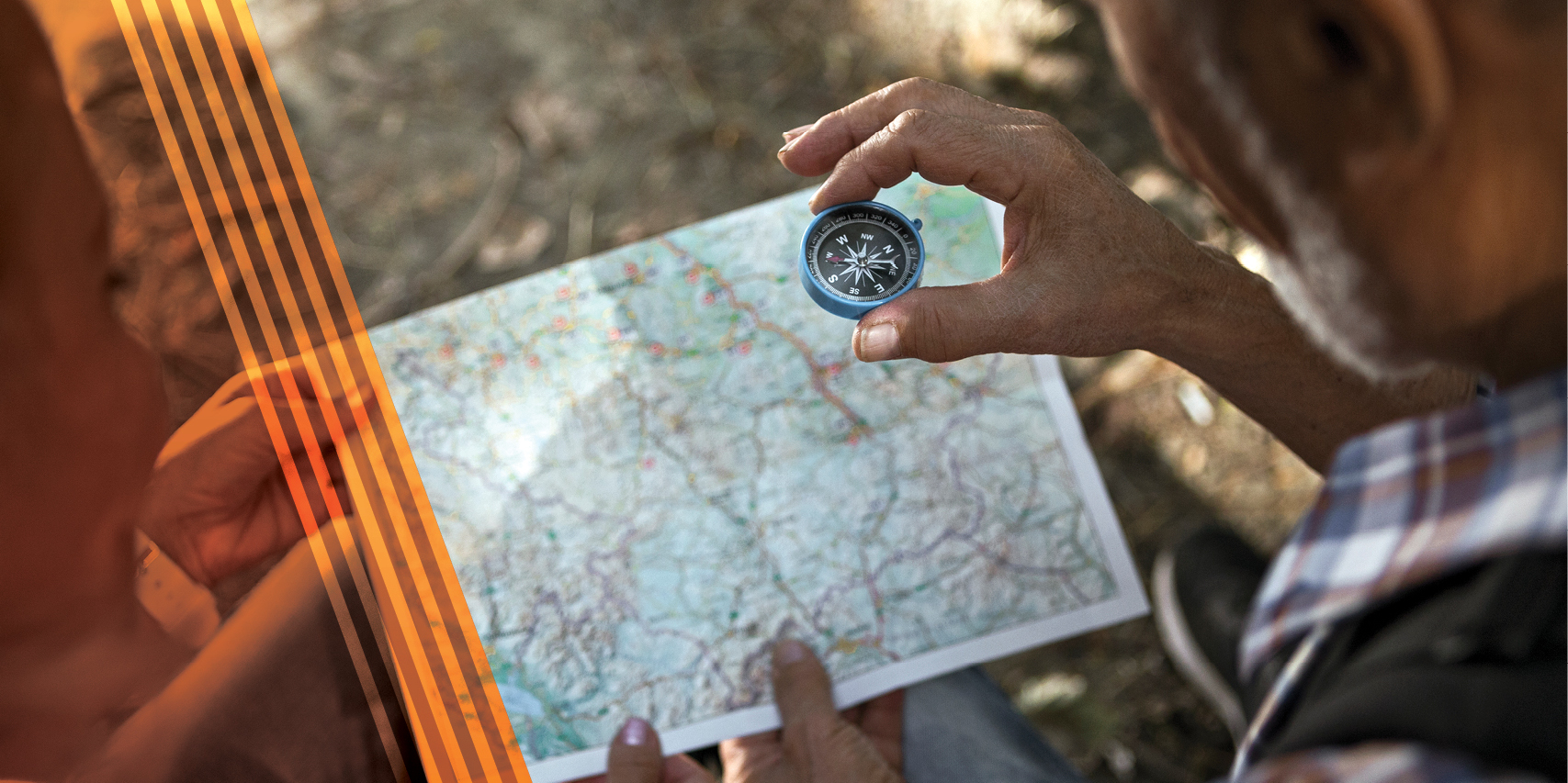 Two people looking at a compass and a map.
