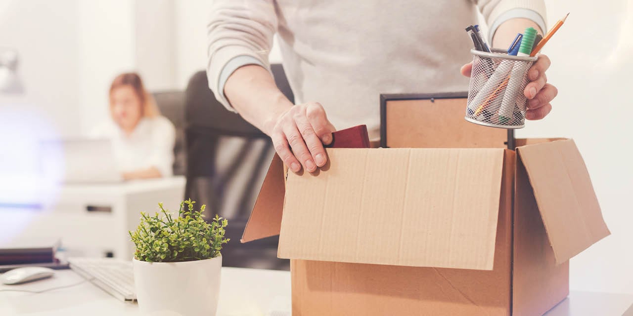 Man packing desk contents into a box.