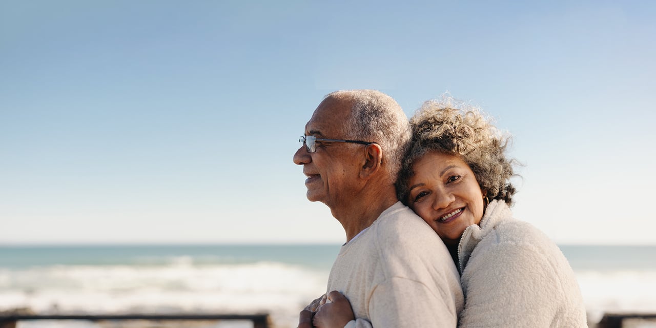 Couple hugging on beach near body of water