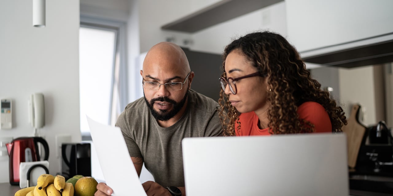 Couple looking at papers and a laptop