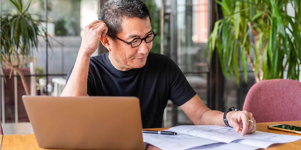 Man sitting at a desk looking at paperwork.