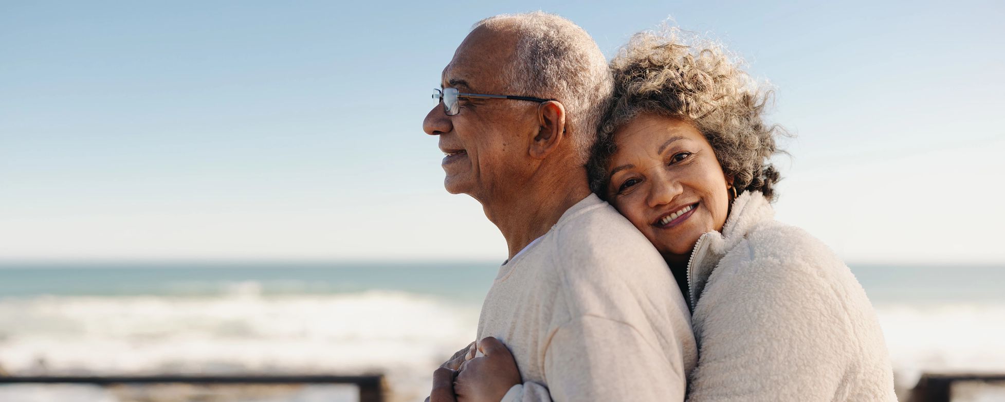 Couple hugging on beach near body of water