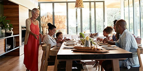 Multi-generational family sitting down for a meal.