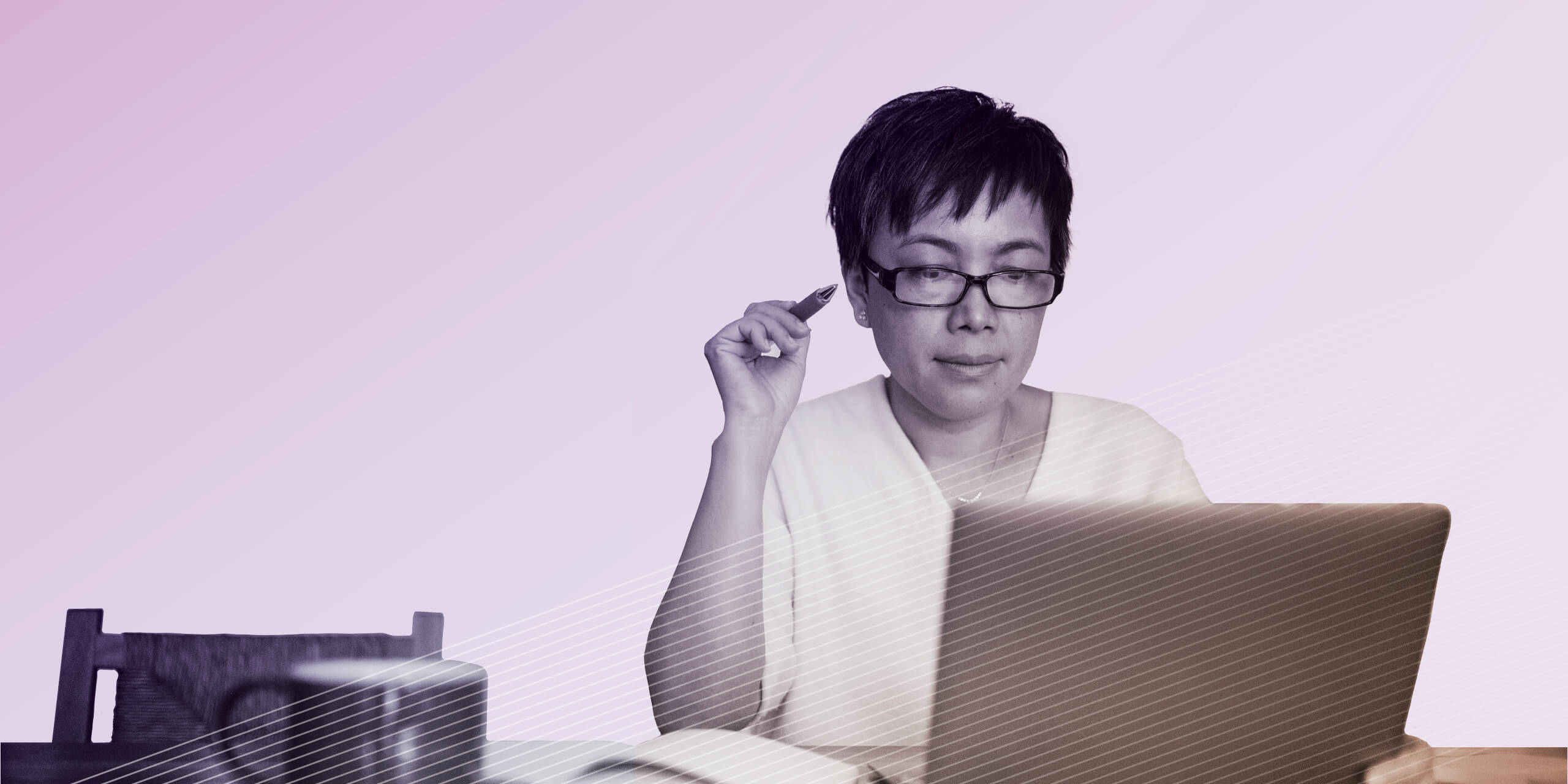 Woman sitting at table looking at laptop