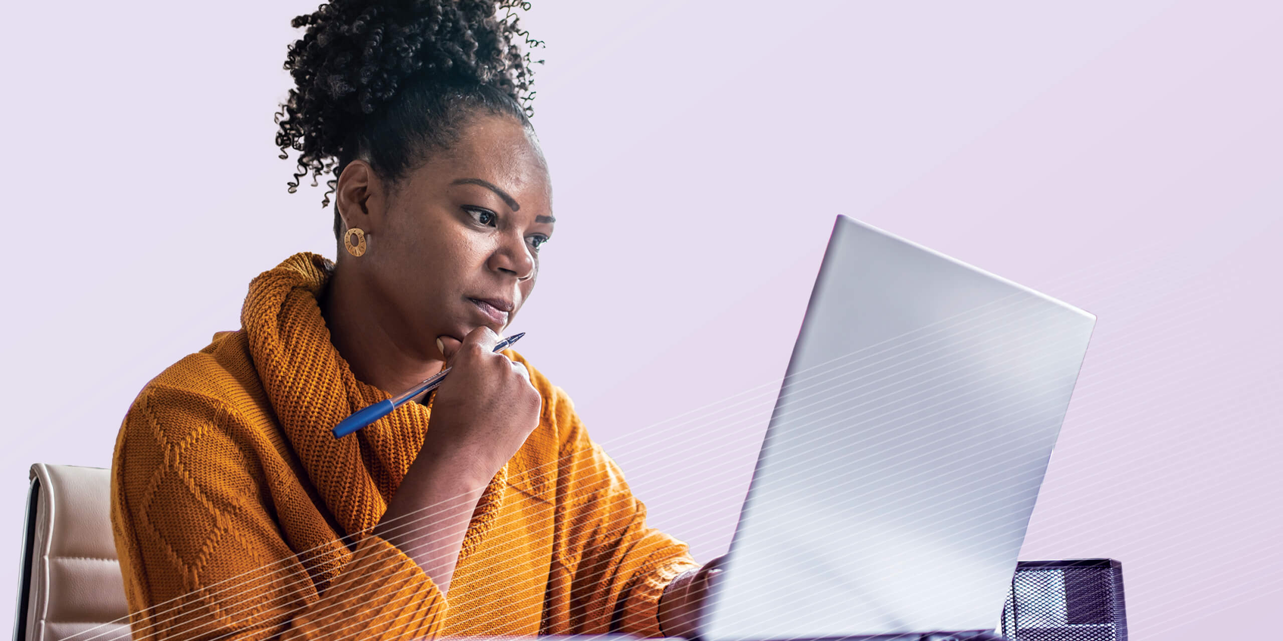 Woman sitting at desk looking at laptop