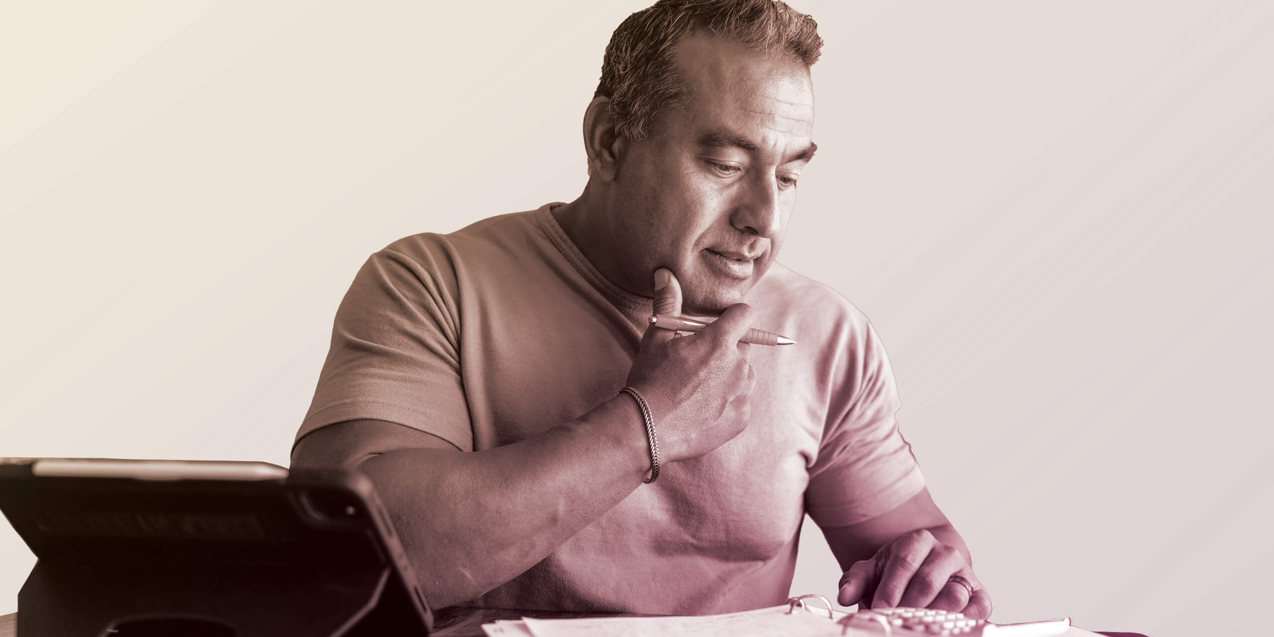 Man reviewing paperwork with calculator