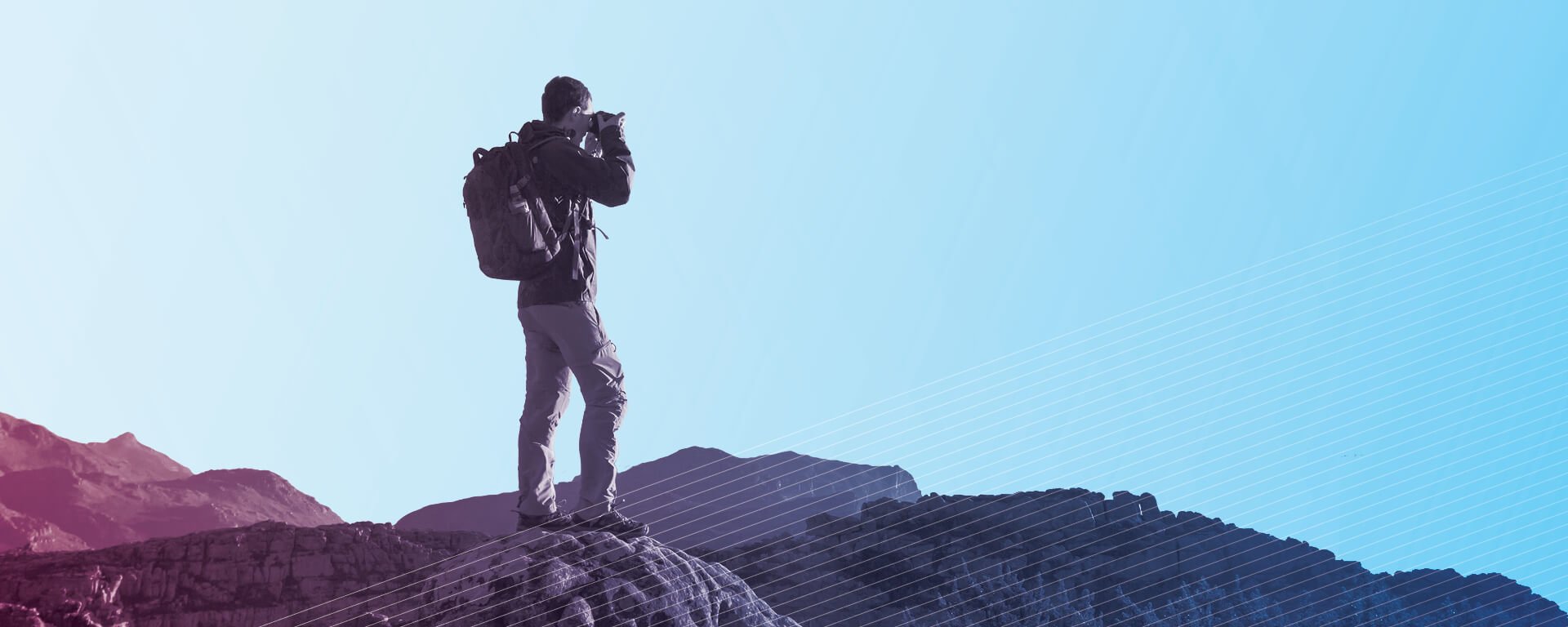 Man taking photos from atop a mountain