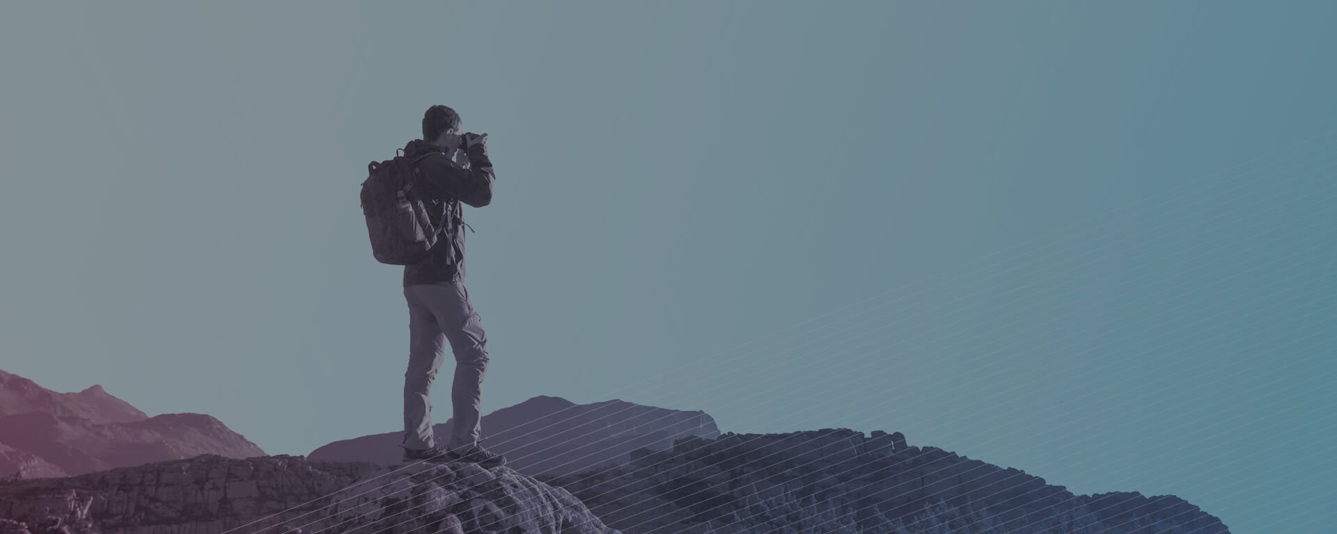 Man taking photos from atop a mountain