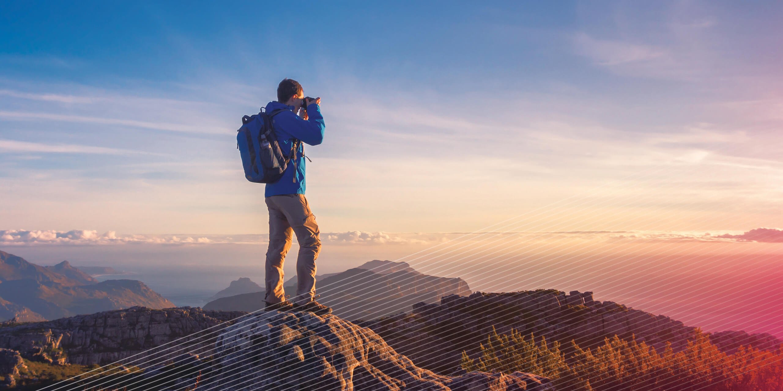 Man taking photos from atop a mountain