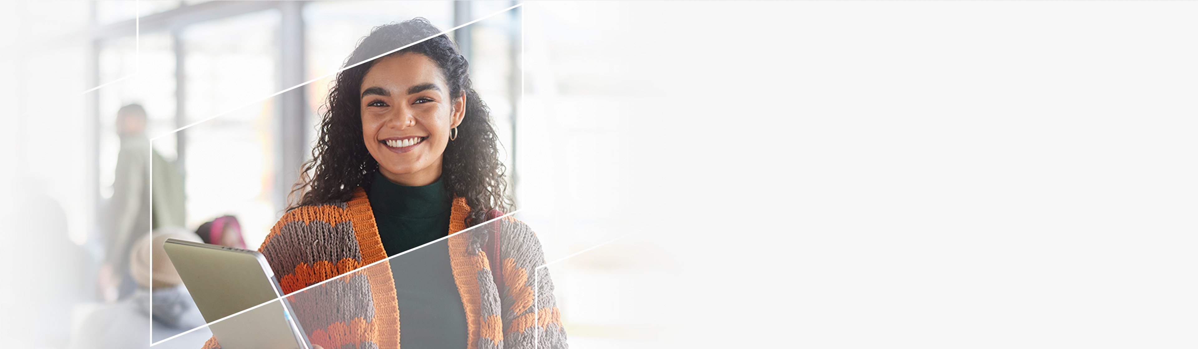 a smiling young woman holding a stack of books