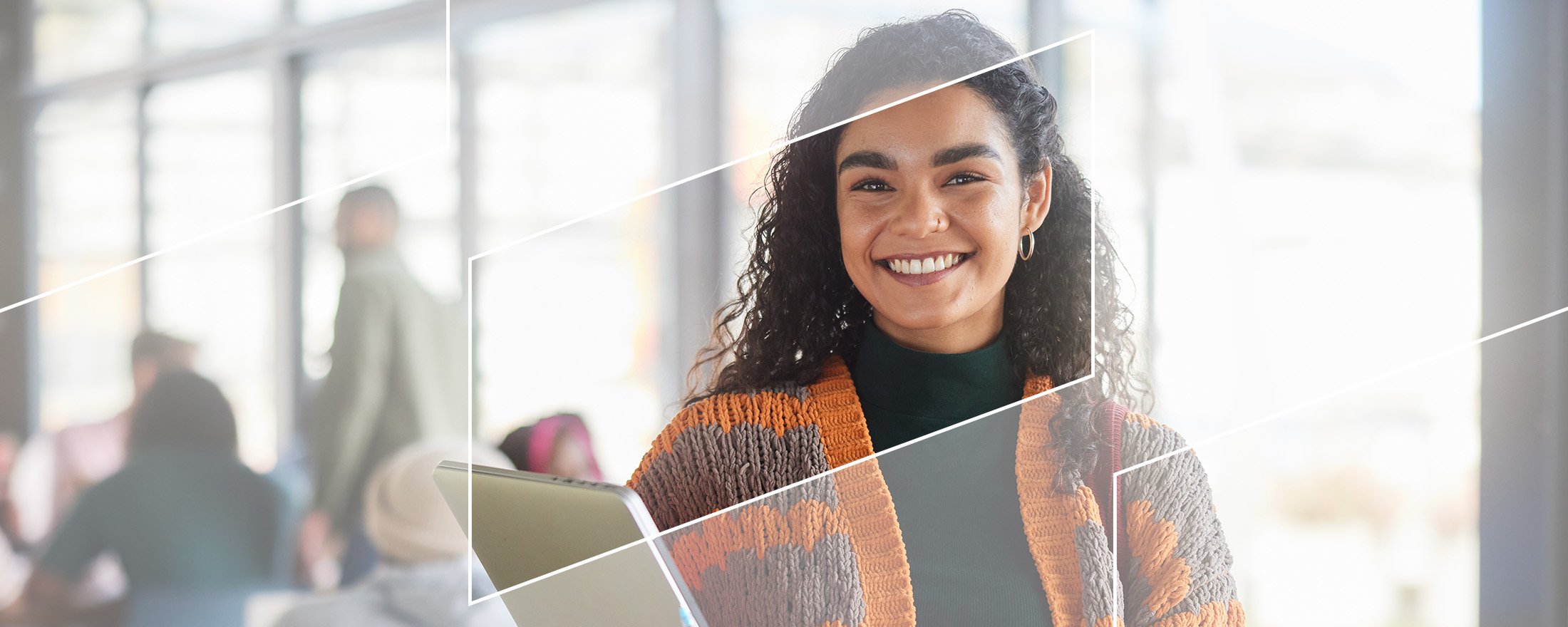 a smiling young woman holding a stack of books