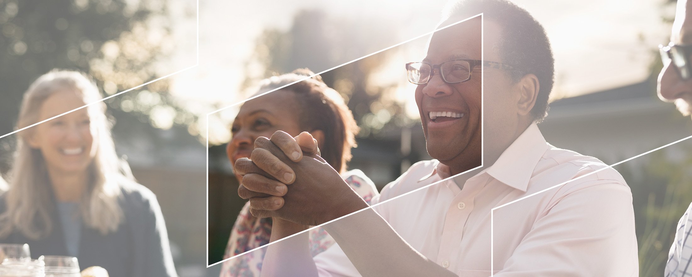Smiling group of middle-aged people gathered at table setting.