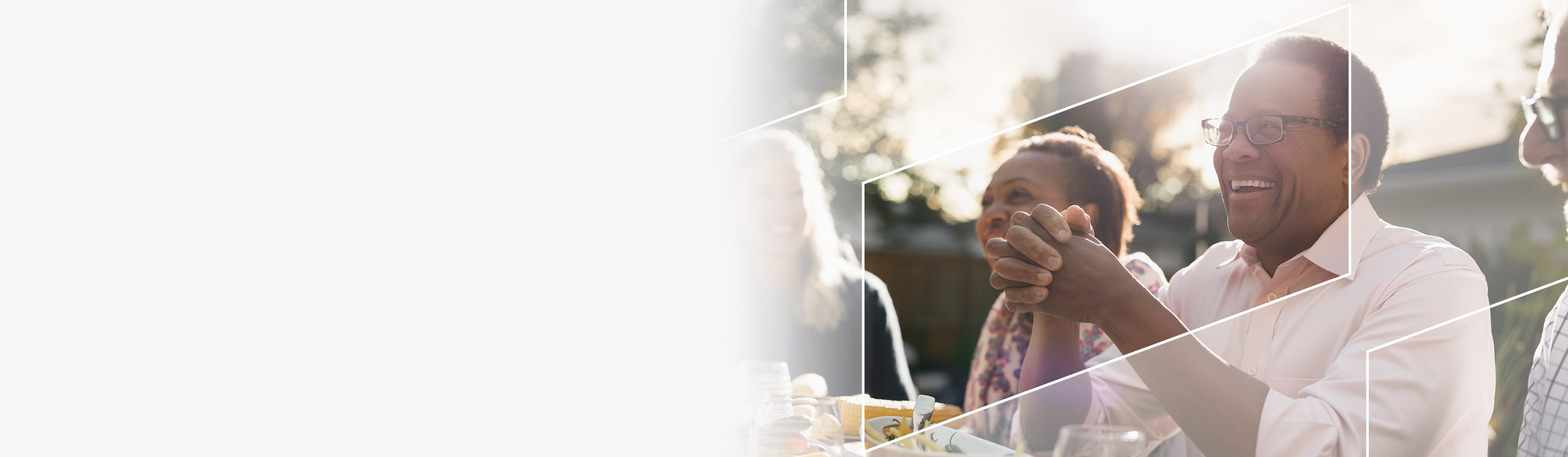 Smiling group of middle-aged people gathered at table setting.