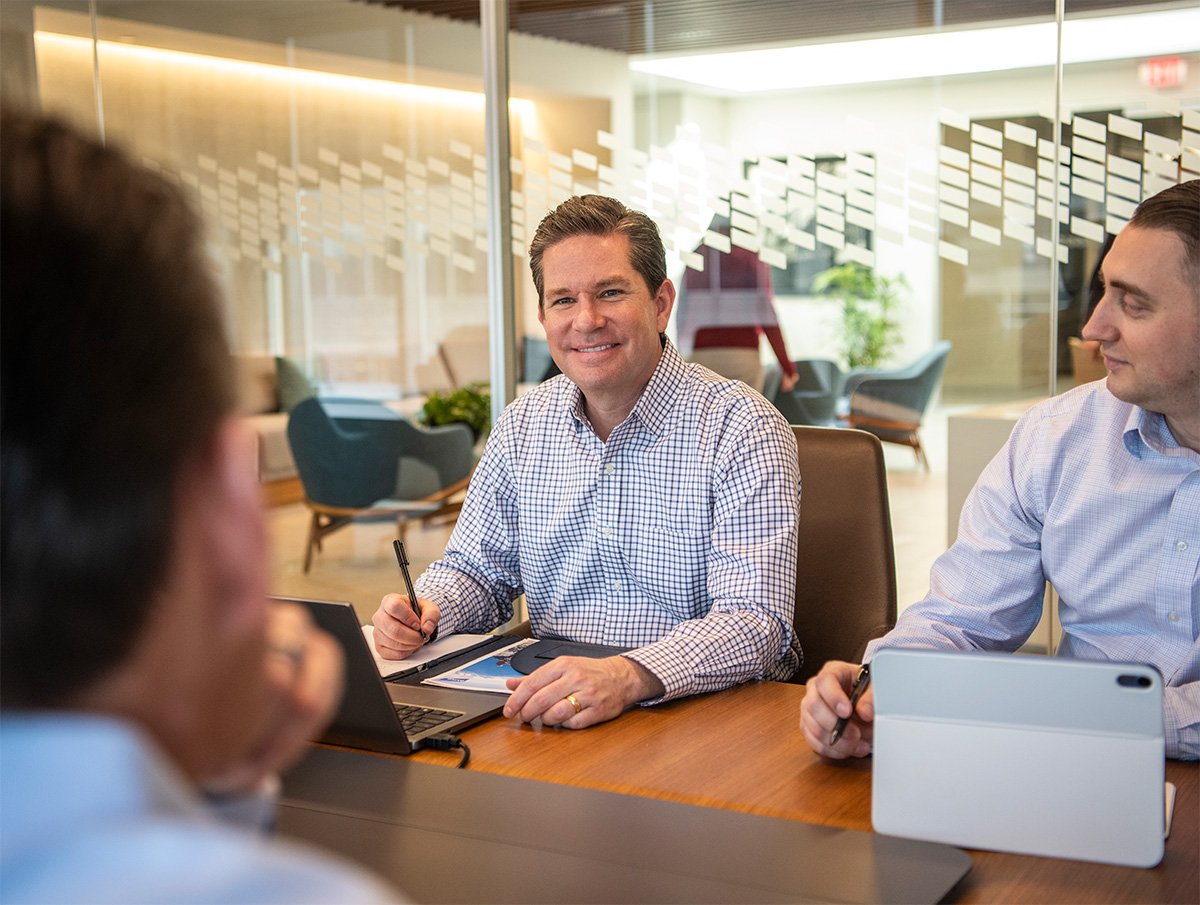 Candid of three Baird associates in a conference room