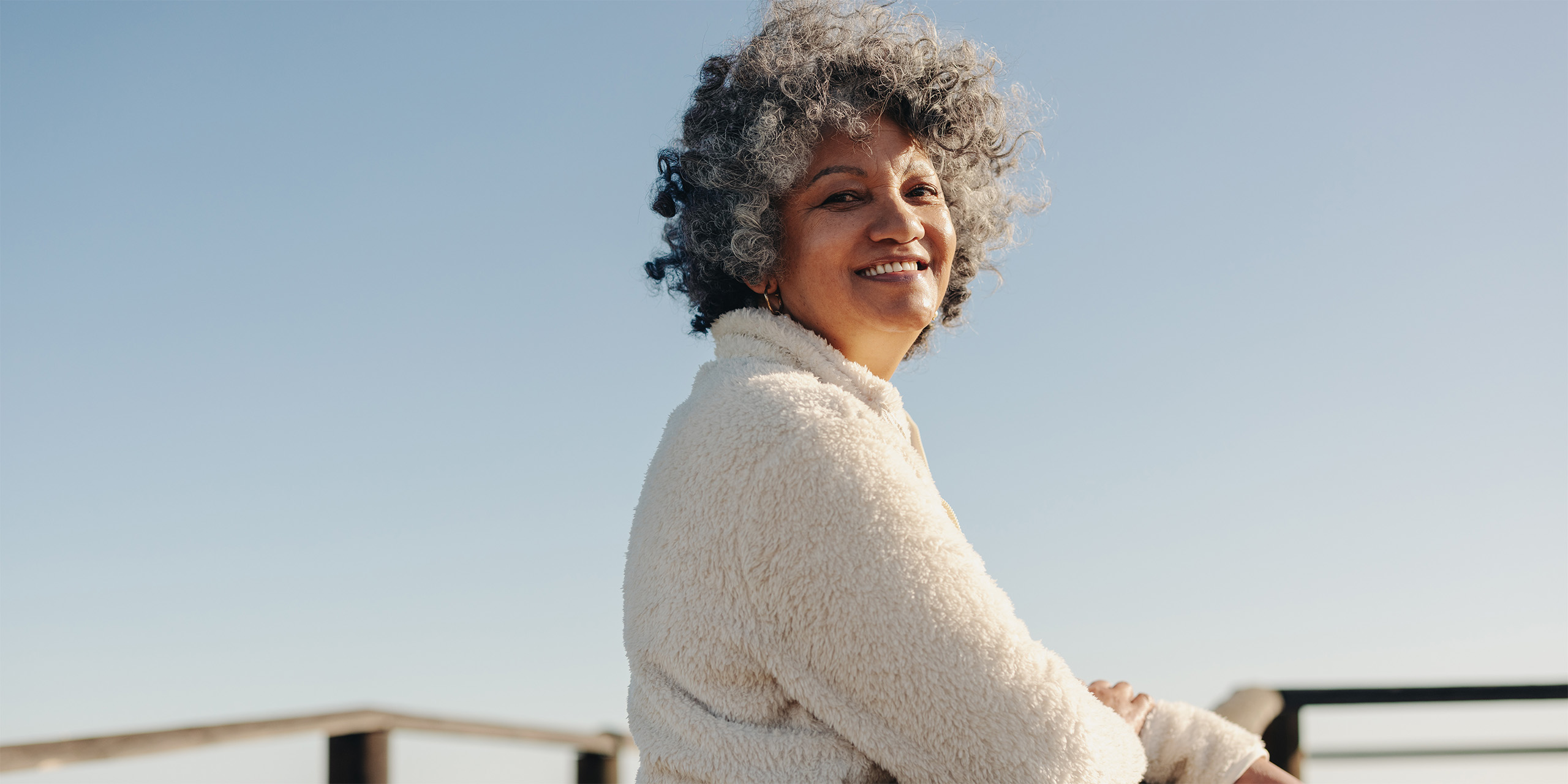 Woman standing on a pier smiling