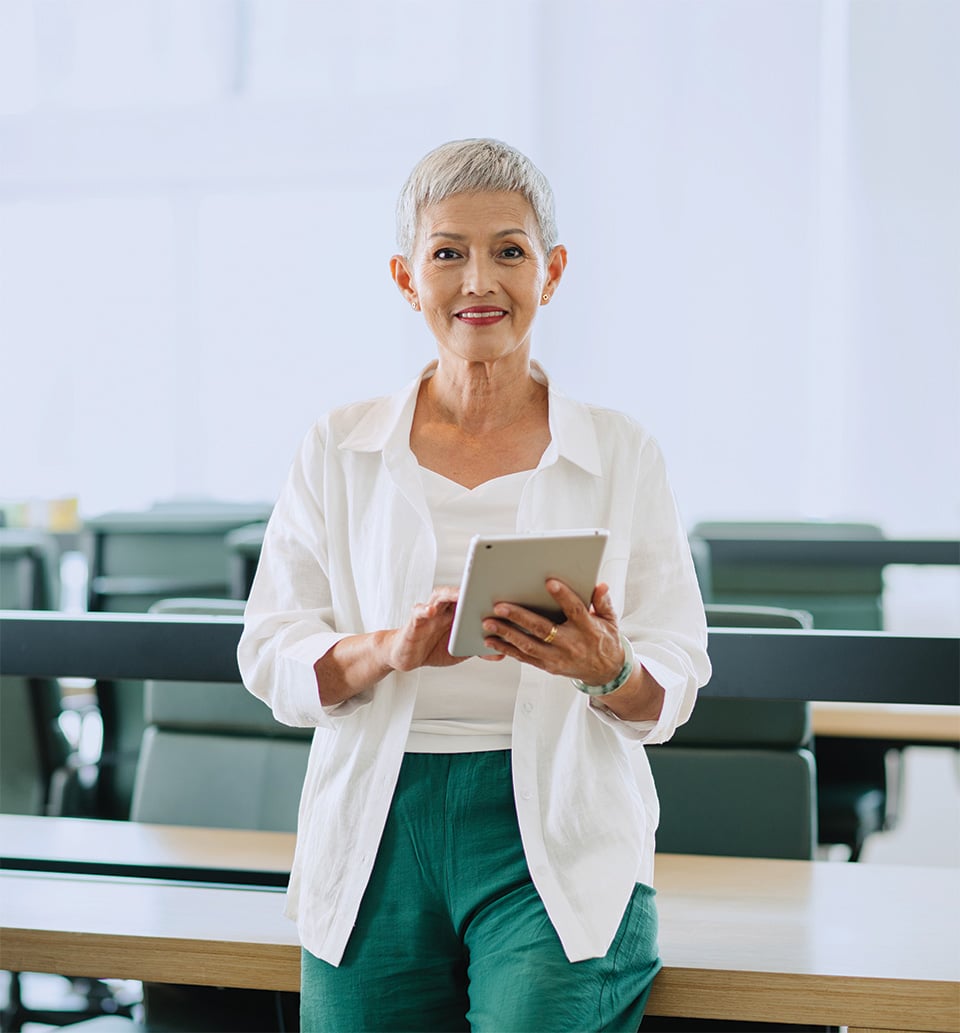 Woman holding a tablet in a lecture hall setting